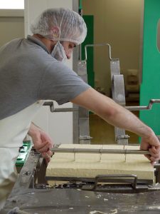 Mitarbeiter schneiden den Tofu in Blöcke. (Foto: dpa)