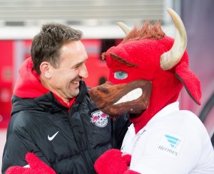 2. Bundesliga - 25. Spieltag: RB Leipzig - Fortuna Düsseldorf am 16.03.2015 in Leipzig (Sachsen). Leipzigs Trainer Achim Beierlorzer umarmt das Maskottchen. Foto: Peter Endig/dpa (Wichtiger Hinweis: Aufgrund der Akkreditierungsbestimmungen der DFL ist die Publikation und Weiterverwertung im Internet und in Online-Medien während des Spiels auf insgesamt fünfzehn Bilder pro Spiel begrenzt.) +++(c) dpa - Bildfunk+++