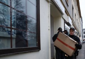 In den Kartons tragen Polizisten Beweismittel davon. (Foto: dpa)