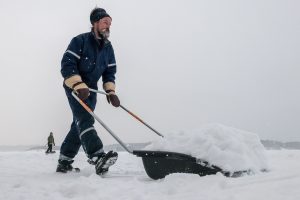 Ein Mann schiebt Schnee auf dem Saimaa-See. (Foto: dpa)
