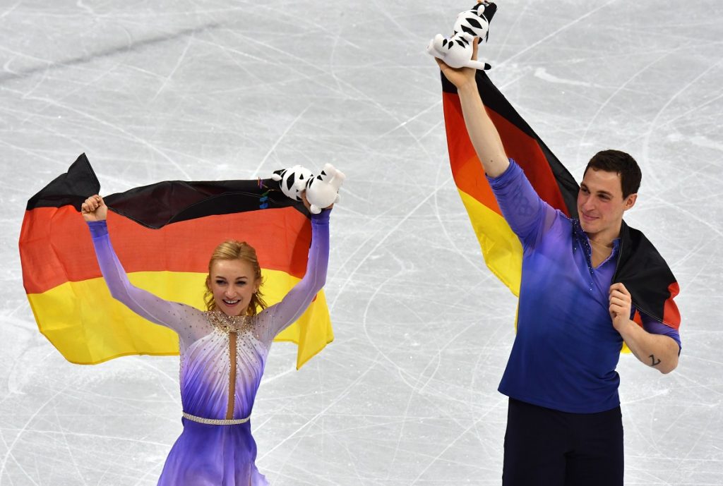 15.02.2018, Südkorea, Gangneung, Olympia, Eiskunstlauf, Paare, Kür in der Gangneung Ice Arena. Sieger Aljona Savchenko und Bruno Massot aus Deutschland jubeln nach der Siegerehrung mit der Deutschlandflahne. Sie gewannen Gold. Foto: Peter Kneffel/dpa +++ dpa-Bildfunk +++