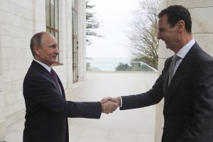 ARCHIV - Der russische Präsident Wladimir Putin (l) und Syriens Präsident Baschar al-Assad geben sich am 20.11.2017 in Sotschi (Russland) die Hand.
