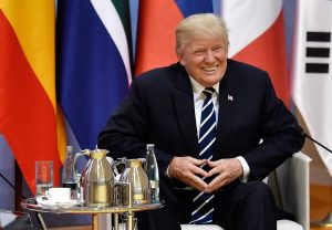 ARCHIV - US-Präsident Donald Trump lächelt am 07.07.2017 beim G20-Gipfel in Hamburg.