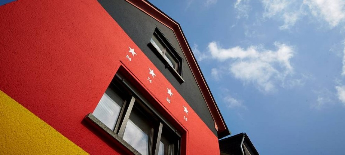 Haus in schwarz, rot, gold