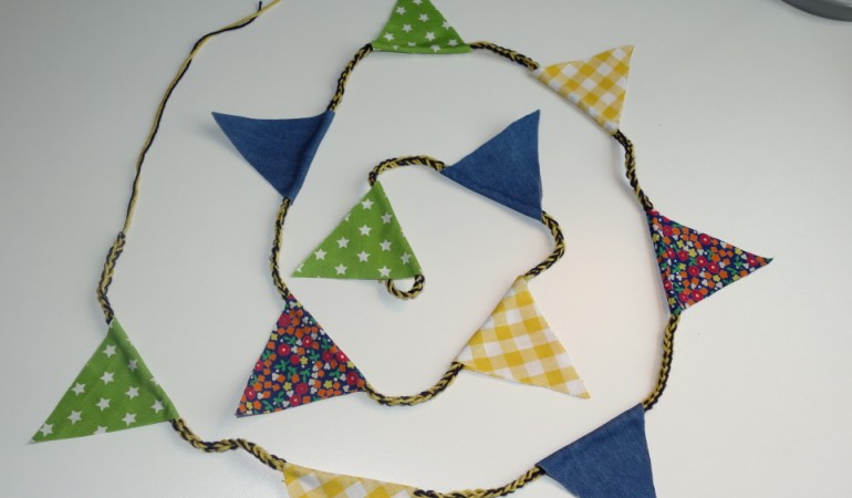 Aus Wolle und Stoffresten bastelst du diese Wimpelkette. (Foto: dpa)