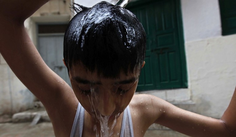 Wer kann, verschafft sich in Pakistan Abkühlung. Zum Beispiel, indem er sich Wasser über den Kopf schüttet. (Foto: dpa)