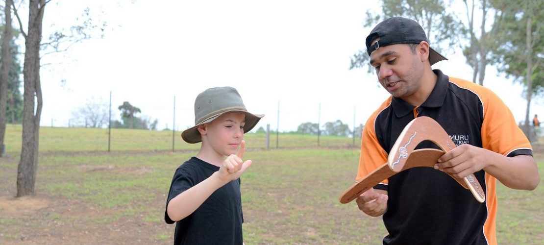 Josh Nicholls erklärt Billy Rosaguti worauf er beim Werfen des Bumerangs achten muss. (Foto: dpa)