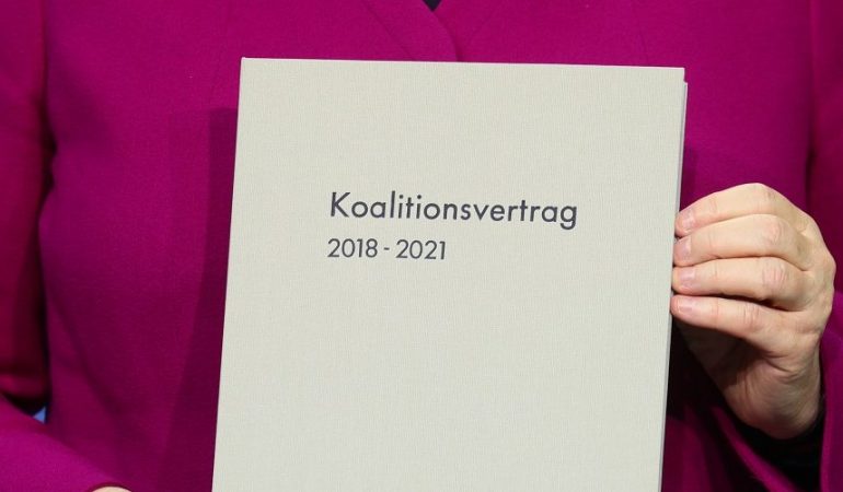 Bundeskanzlerin Angela Merkel (CDU) hält im Paul-Löbe-Haus den unterschriebenen Koalitionsvertrag in den Händen. (Foto: dpa)