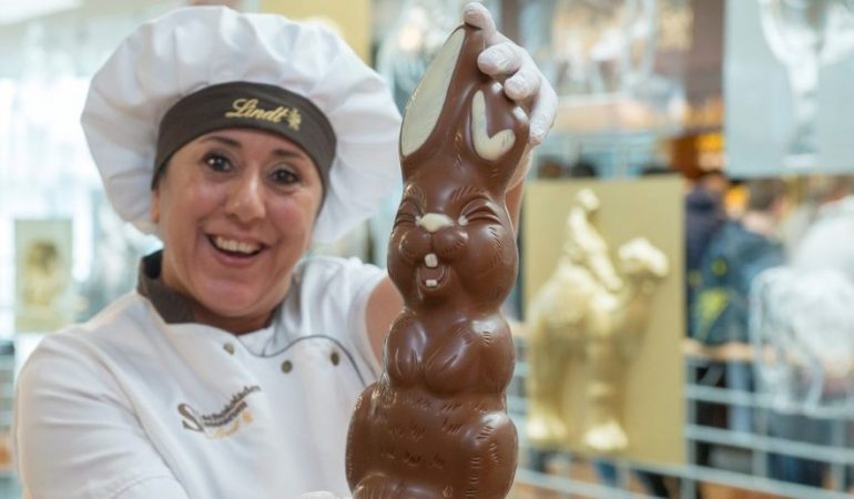 Eine Mitarbeiterin des Schokomuseum hält lachend einen Schokohasen in die Kamer. (Foto: Uwe Weiser)