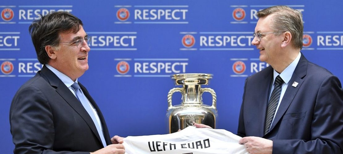 Der Präsident des Deutschen Fußballbundes Reinhard Grindel (r) übergibt die Bewerbungsunterlagen für die EM 2024 an UEFA-Generalsekretär Theodore Theodoridis, sowie ein Trikot mit der Rückennummer UEFA Euro 24. (Foto: dpa)