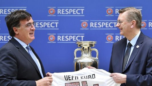 Der Präsident des Deutschen Fußballbundes Reinhard Grindel (r) übergibt die Bewerbungsunterlagen für die EM 2024 an UEFA-Generalsekretär Theodore Theodoridis, sowie ein Trikot mit der Rückennummer UEFA Euro 24. (Foto: dpa)