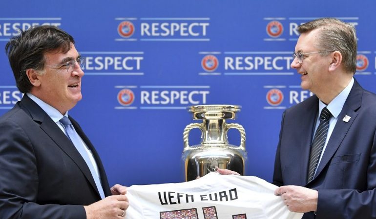 Der Präsident des Deutschen Fußballbundes Reinhard Grindel (r) übergibt die Bewerbungsunterlagen für die EM 2024 an UEFA-Generalsekretär Theodore Theodoridis, sowie ein Trikot mit der Rückennummer UEFA Euro 24. (Foto: dpa)