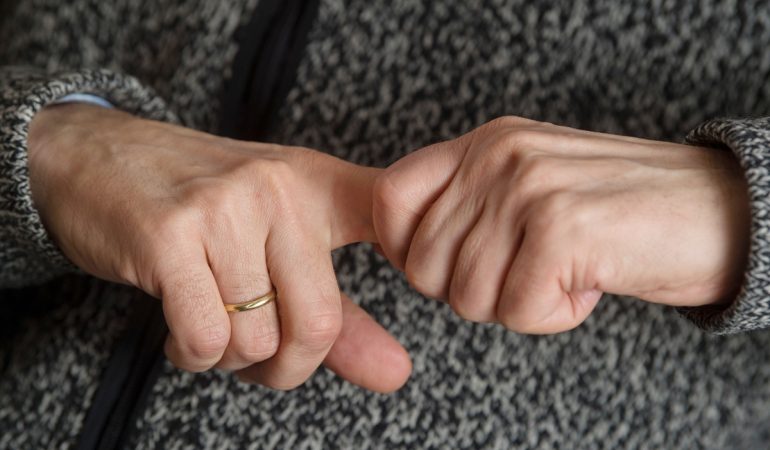 Ein Mann versucht, seine Fingergelenke knacken zu lassen (gestellte Szene).