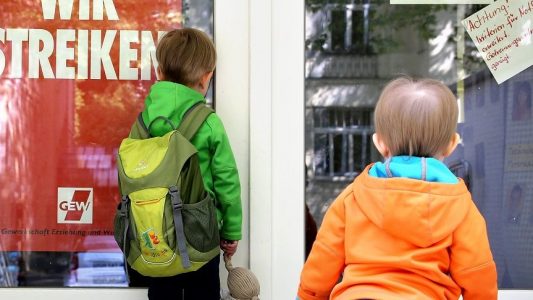 Zwei kleine Kinder stehen am 18.05.2015 an der Tür eines wegen Streik geschlossenen Kindergartens in Leipzig (Sachsen).