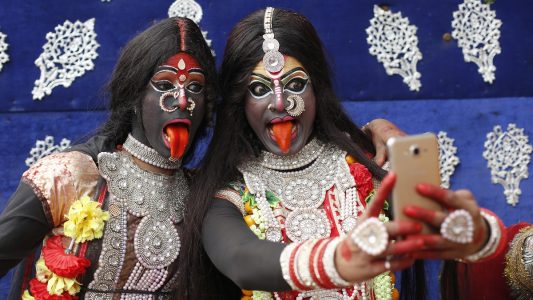 13.02.2018, Indien, Allahabad: Zwei als Hindu-Gottheit Kali verkleidete Jugendliche machen im Rahmen des Shivaratri Festivals ein Selfie.