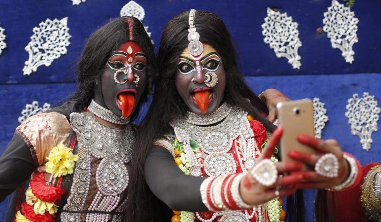 13.02.2018, Indien, Allahabad: Zwei als Hindu-Gottheit Kali verkleidete Jugendliche machen im Rahmen des Shivaratri Festivals ein Selfie.