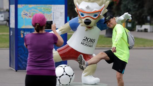 Fußballfans machen vor dem WM-Stadion mit dem Maskottchen, dem Wolf Sabiwaka, ein Erinnerungsfoto. (Foto: Lee Jin-Man/AP/dpa)