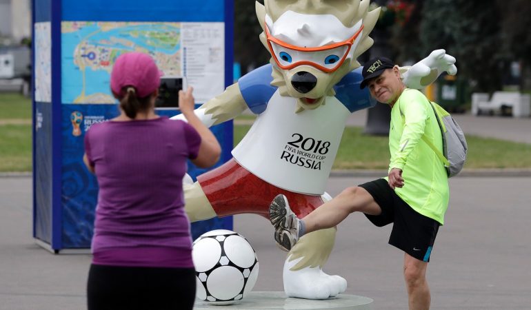 Fußballfans machen vor dem WM-Stadion mit dem Maskottchen, dem Wolf Sabiwaka, ein Erinnerungsfoto. (Foto: Lee Jin-Man/AP/dpa)