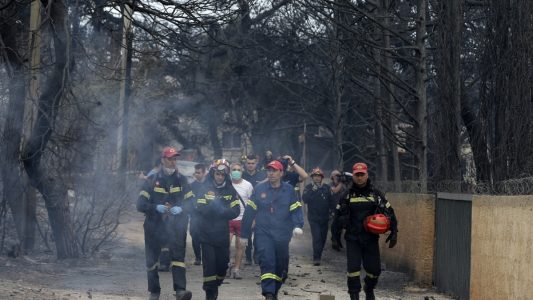 Feuerwehrleute inspizieren ein verbranntes Gebiet. Großbrände nahe Athen haben viele Menschen das Leben gekostet. (Foto: dpa)