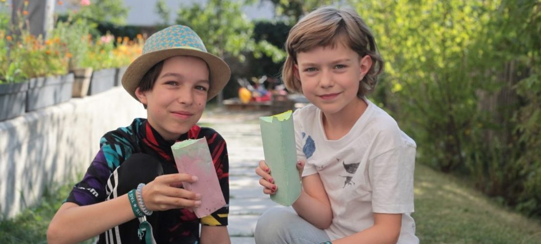 Juli (l) und Tilda (r) freuen sich über die selbst gemachte Straßenkreide. Foto: Corinna Schwanhold/dpa