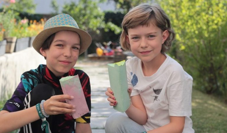 Juli (l) und Tilda (r) freuen sich über die selbst gemachte Straßenkreide. Foto: Corinna Schwanhold/dpa