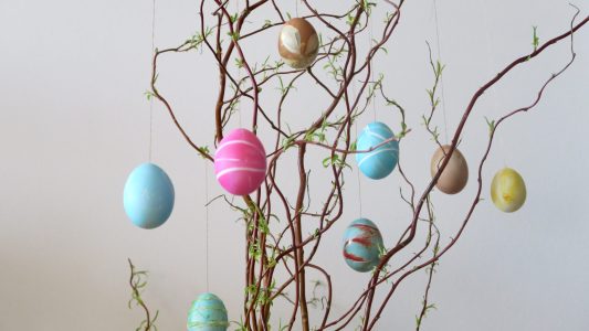 Ostereier mit Gummibändern und Blüten